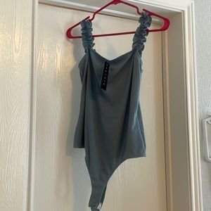 Bodysuit never been worn with ruffle sleeves size L fits like a medium